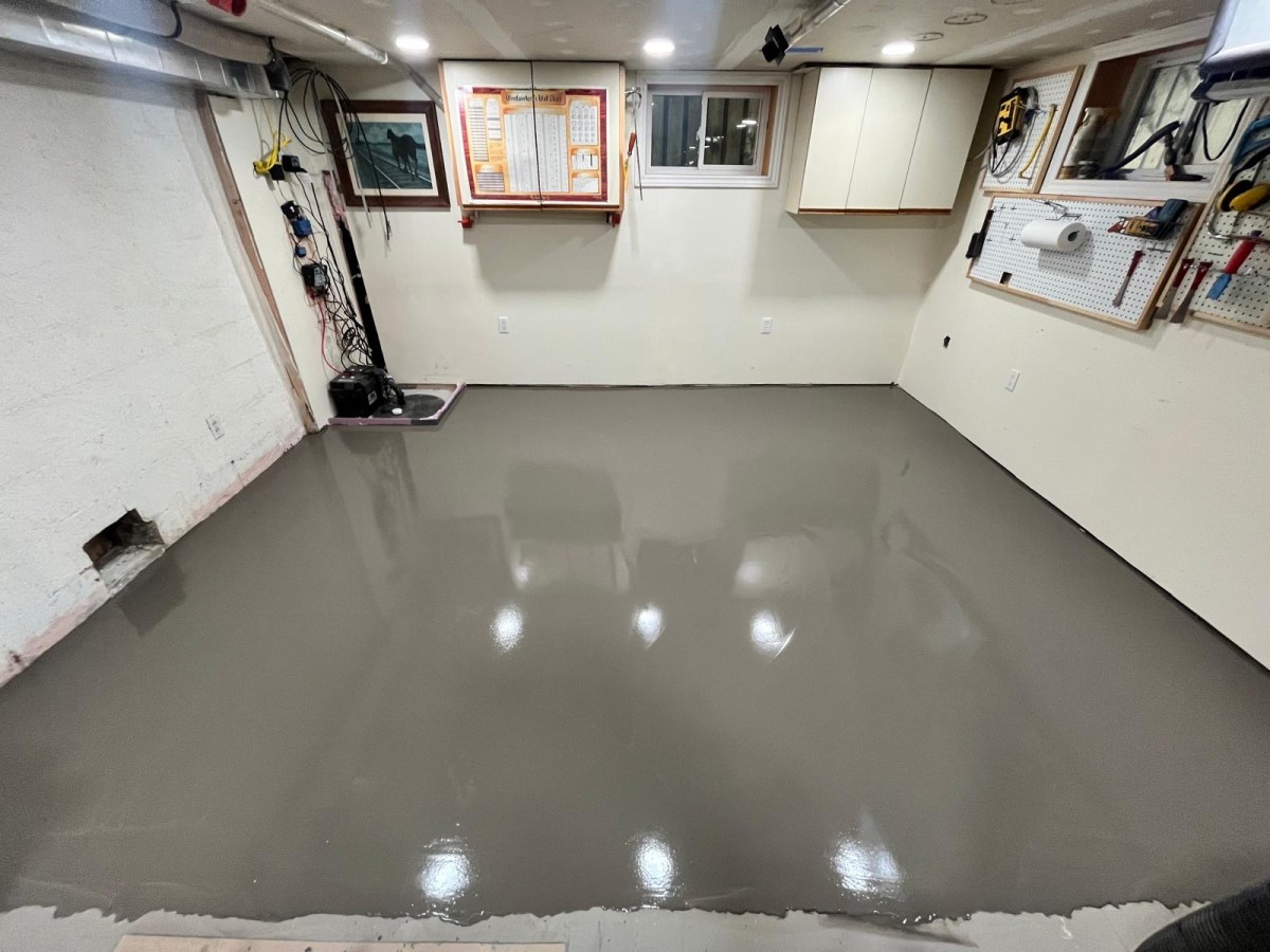 Self-levelling cement covering a full home workshop floor with tool storage along the walls